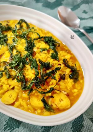 Una foto de Arroz meloso con rodaja de pota y rúcula frita