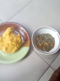 A picture of Okro soup with yellow garri.