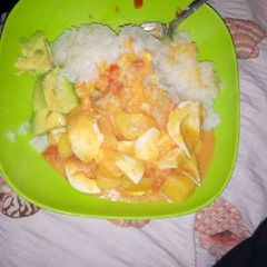 A picture of Cooked rice,potato-egg curry and avocado.
