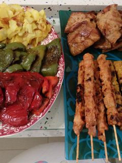 Una foto de Barbacoa de secreto ibérico y pinchitos con pimientos y patatas fritas