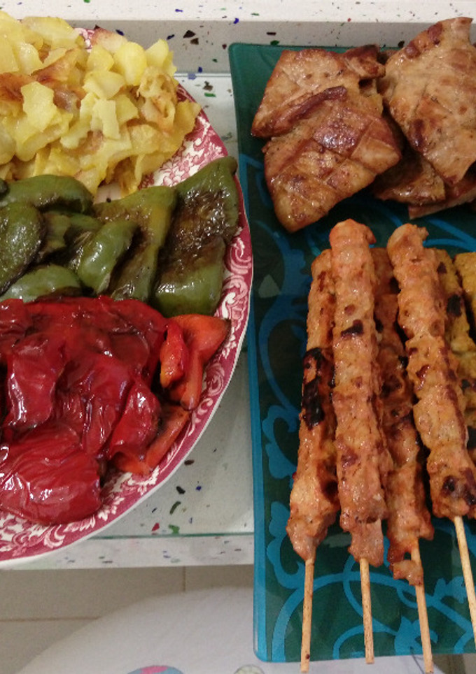 Una foto de Barbacoa de secreto ibérico y pinchitos con pimientos y patatas fritas