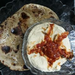 A picture of Hummus with whole wheat pita bread and tomato chutney.