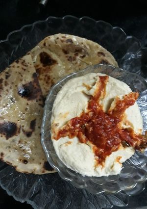 A picture of Hummus with whole wheat pita bread and tomato chutney.