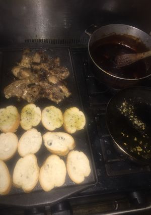 Una foto de Pollo con salsa bbq picante y pan al ajillo