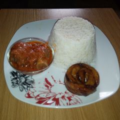 A picture of White Rice, Goat meat Stew and Fried Plantain.