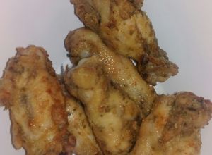 Una foto de Alitas de pollo rebozadas con harina, con papas fritas finas