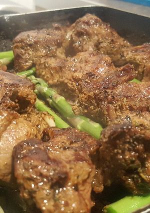 A picture of Jerk steak with asparagus.