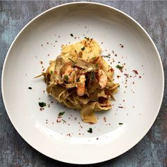 A picture of Fresh pappardelle with artichokes and prawns.