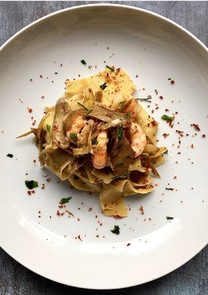 A picture of Fresh pappardelle with artichokes and prawns.