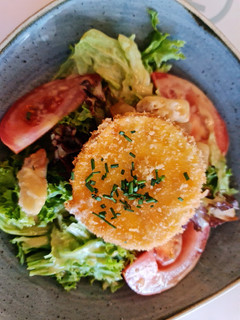 Una foto de Ensalada de lechuga de batavia y roble con queso de rulo frito