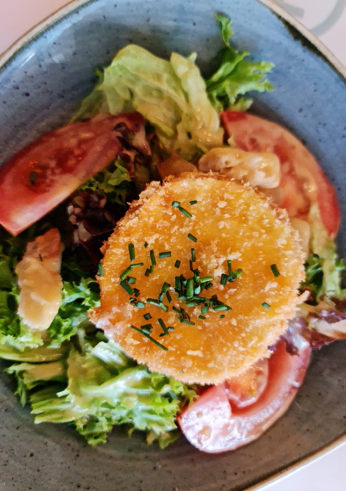 Una foto de Ensalada de lechuga de batavia y roble con queso de rulo frito