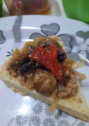 Una foto de Pan con atún, hongos, cebolla y morrón
