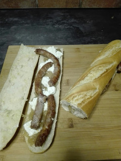 Una foto de Bocata de salchichas con queso de cabra y cebolla caramelizada