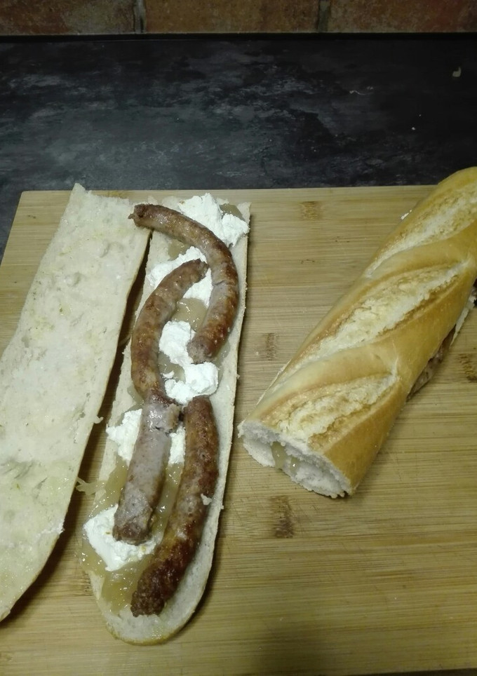 Una foto de Bocata de salchichas con queso de cabra y cebolla caramelizada