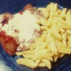 Una foto de Milanesas de pollo con queso y papas fritas