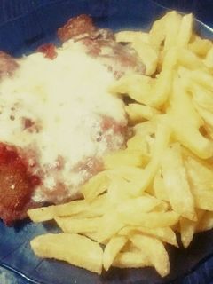 Una foto de Milanesas de pollo con queso y papas fritas