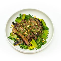 A picture of Grilled Lamb Steak with Pistachios, Charred Leeks, and Roasted Shallot Vinaigrette.