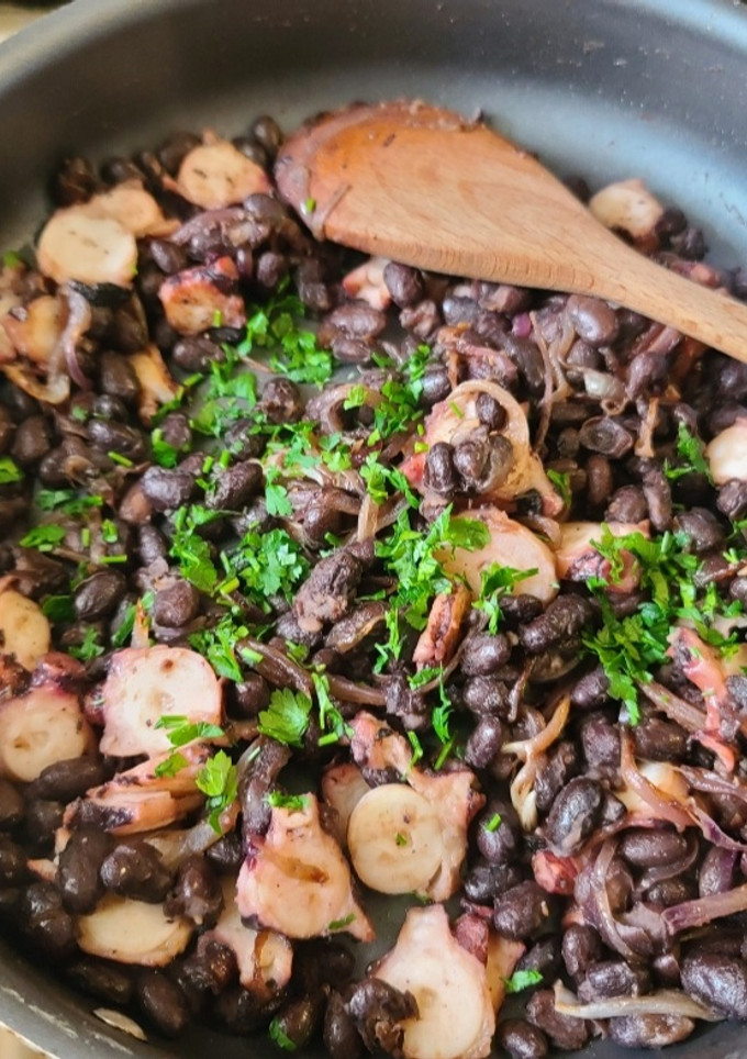 Una foto de Poroto negro con cebolla caramelizada y pulpo
