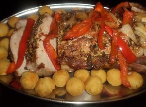 Una foto de Bondiola de cerdo en colchón de morones y cebollas caramelizadas y papas noisettes
