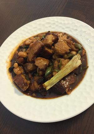 A picture of Stew pork belly with baked beans.