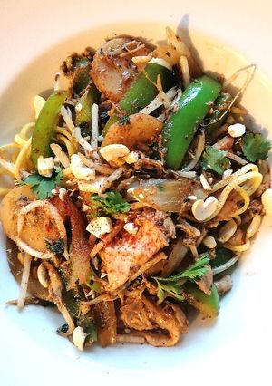 A picture of Shredded chicken with black bean and veg noodles.