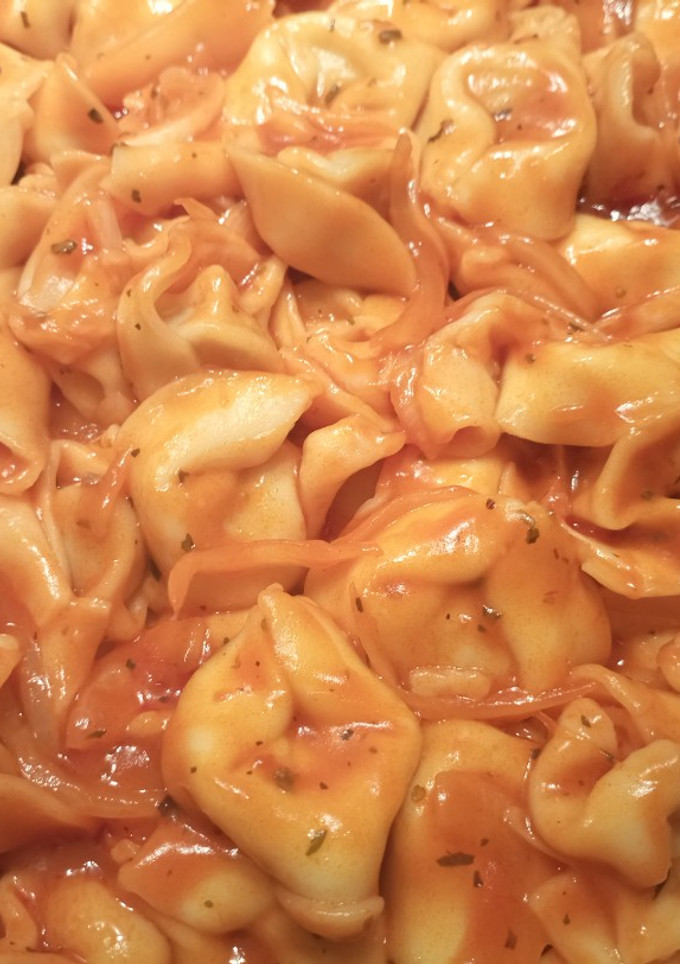 Una foto de Tortelloni rellenos de carne en tomate