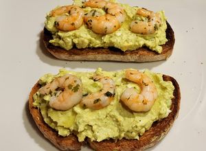 Una foto de Tostas con aguacate, huevo, salsa mahonesa y langostinos