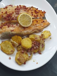 Una foto de Truchas arcoíris con cama de papas y cebolla