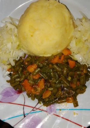 A picture of Mashed potatoes with French beans and veggies.
