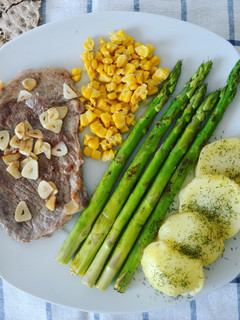 Una foto de Filete de ternera con esparragos trigueros, patata y maíz