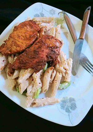 A picture of White sauce pasta with grill chicken.