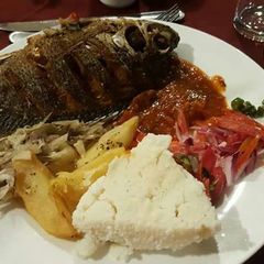 A picture of Fried fish with kachumbari and ugali.