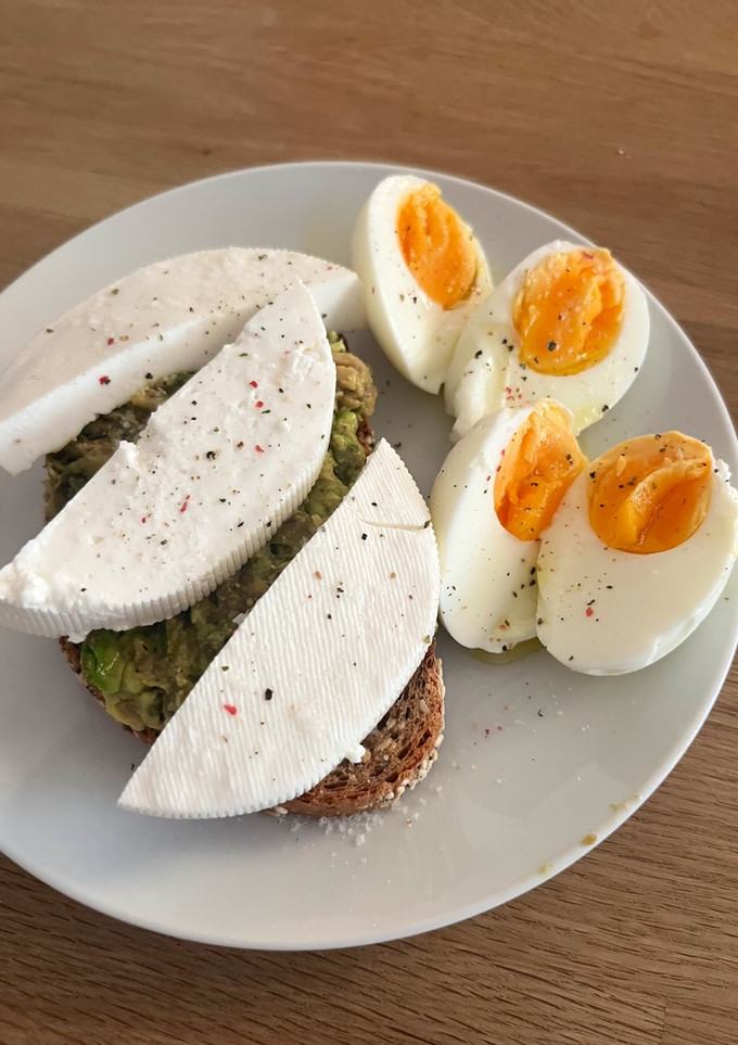 Una foto de Tostada de aguacate con queso fresco y dos huevos cocidos