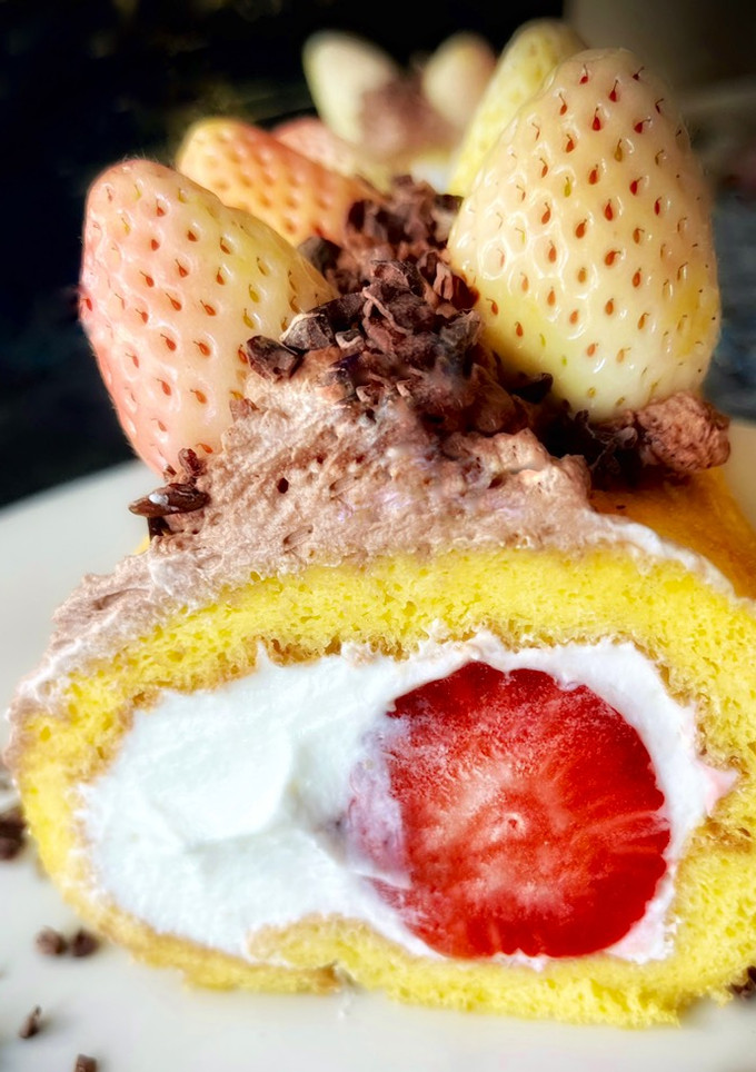 Una foto de Brazo gitano de fresones blancos y rojos con nata y trufa
