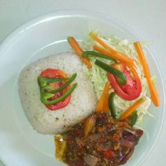 A picture of White rice with ufada stew and vegetables.