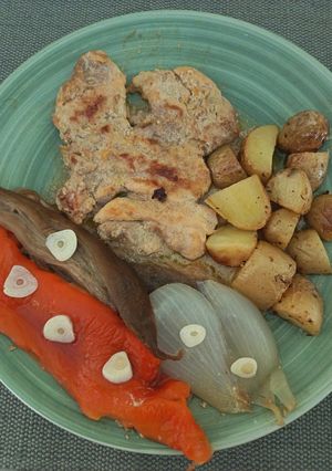 Una foto de Filetes de pollo marinados acompañados de escalivada y patatas al horno con tomillo y limón