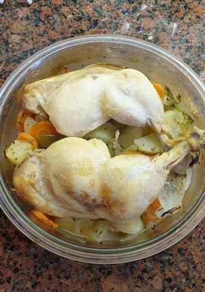 Una foto de Muslos de pollo con patatas y verduras al horno