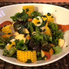 A picture of Salad: Garden Greens with Apple, Sweet Corn, basil pesto and Soft Boiled Eggs.