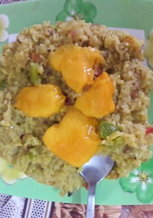 A picture of Moong dal khichdi with onion tomato and capsicum tadka.
