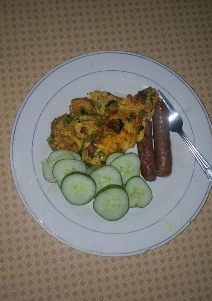 A picture of Fried sausages,eggs and cucumber.