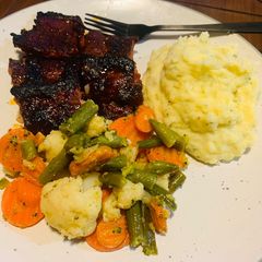 A picture of Ribs with Mashed Potatoes and Mixed Veggies.