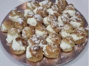 Una foto de postres con nata profiteroles