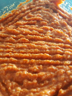 Una foto de Muhammara de pimiento, nueces, y granada