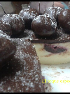 Una foto de Tarta de queso con cobertura de chocolate con cerezas