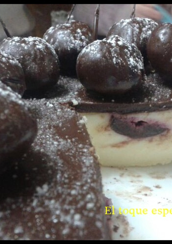 Una foto de Tarta de queso con cobertura de chocolate con cerezas