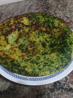 Una foto de Tortilla de patatas cebolla caramelizada y espinacas