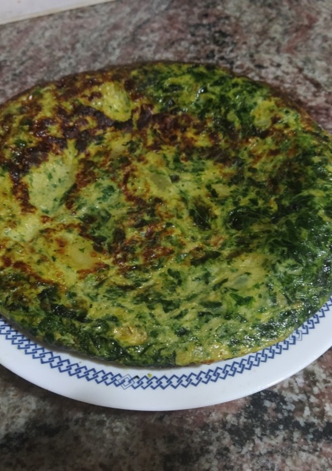 Una foto de Tortilla de patatas cebolla caramelizada y espinacas
