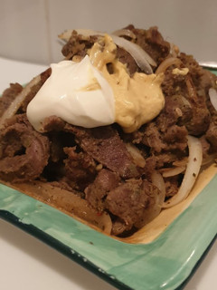 Una foto de Carne de cordero con cebolla marinada al mostaza