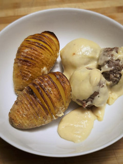 A picture of Meatballs with gravy and roasted potatoes.