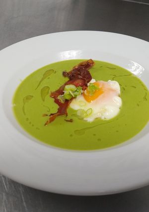Una foto de Crema de guisantes con jamón crocante y huevo
